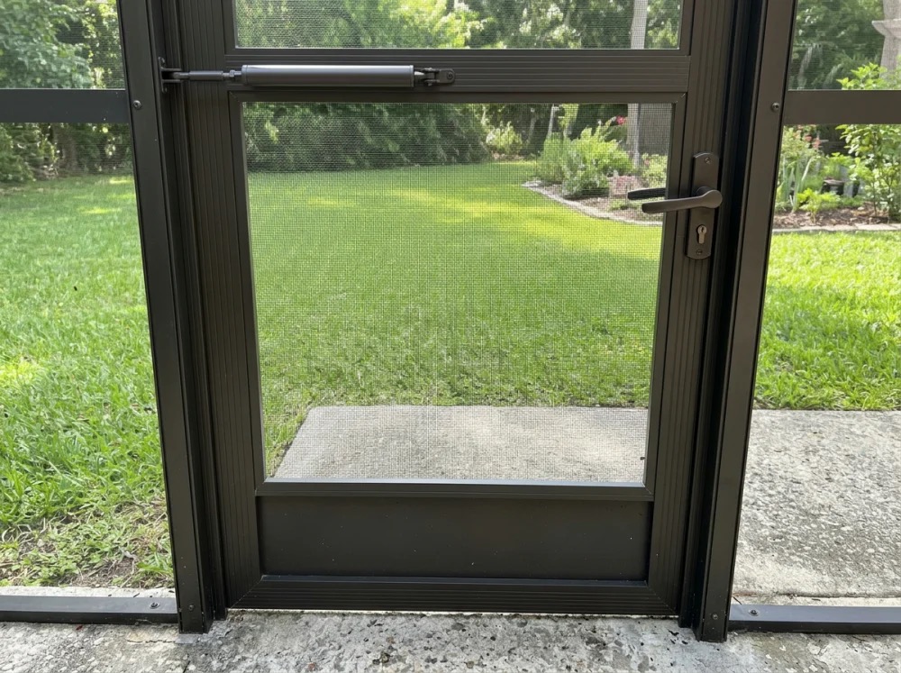 Bronze screen door with lever handle and closer on a Central Florida enclosure